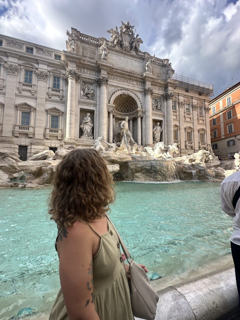 Girl looks at top thing to do in Rome, the Trevi Fountain in the summer
