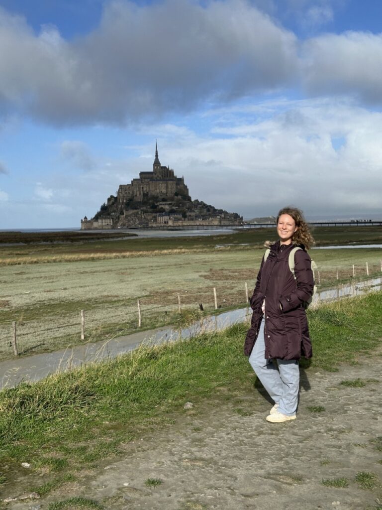 girl stand outside mont saint michel on a first timer paris day trip