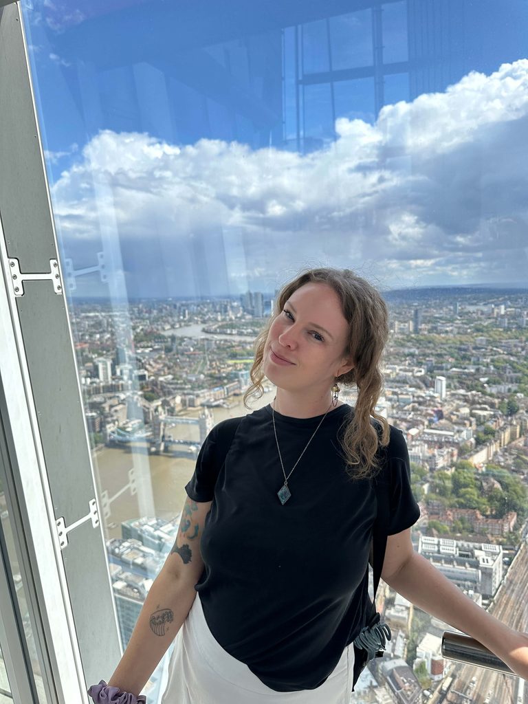 girl poses at the shard in london with city view in background