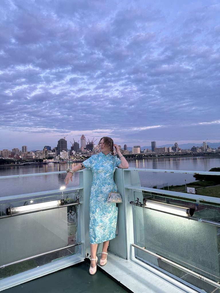 girl wear a qiapo over the taipei skyline from sanchong