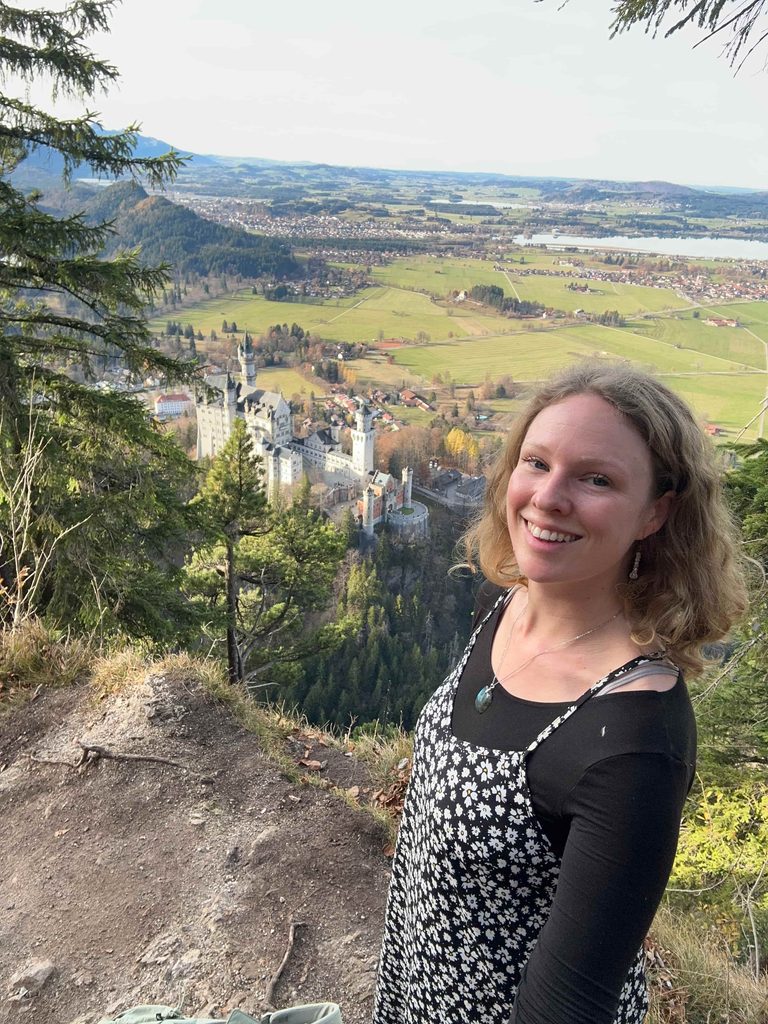girl stands above Neuschwanstein Castle on a hike past Marienbrücke bridge