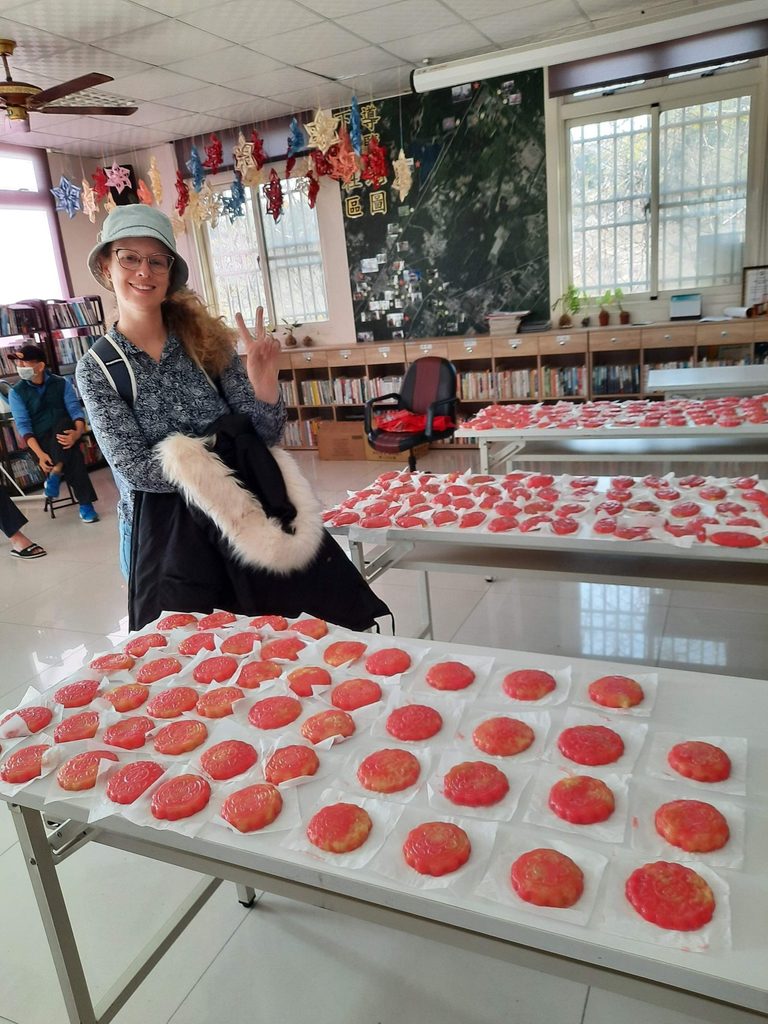 many red tortoise ckaes lay out on tables in a taiwan community center