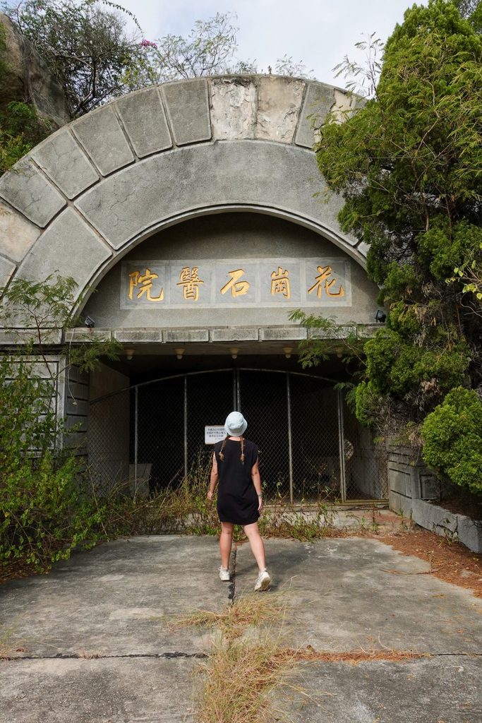 woman standing outside the gates of granite hospital on kinmen island taiwan