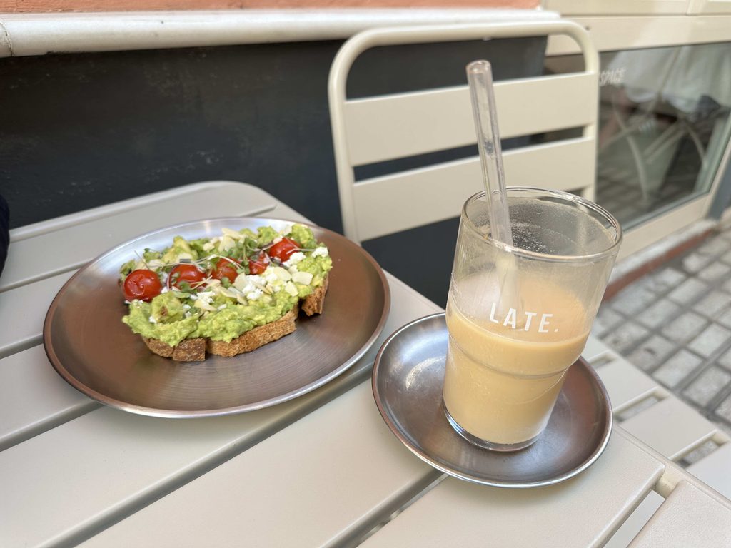 LATE. cafe avocado and tomato on toast and iced late cafe with a workspace area in seville